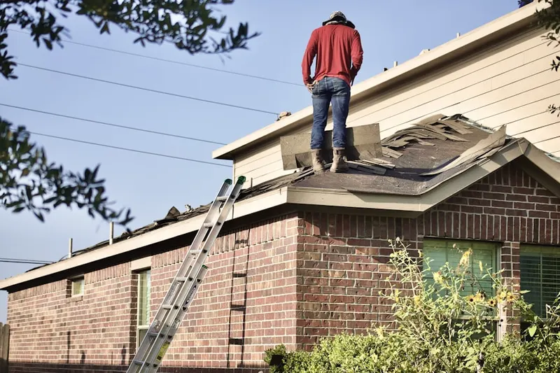 Professional roofer working on a residential roof in Commack